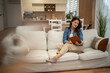 © Migma_Agency - Young woman enjoying reading book on sofa at home