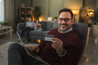 © Miljan Živković - Man shopping online with credit card at home