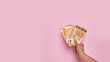 © Beatriz - Horizontal web banner of a hand holding euro banknotes on a pastel pink background with copy space. Earn money, invest and save, cash concept