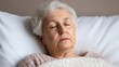 © Nitchalee N. - Senior self care, A serene elderly woman sleeps peacefully in bed, wrapped in a blanket, conveying a sense of calm and tranquility.