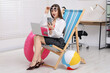 © New Africa - Emotional woman with laptop and smartphone on deckchair in office