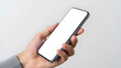 © MuniraStyles - Person holding angled silver smartphone with empty white screen on light surface mockup