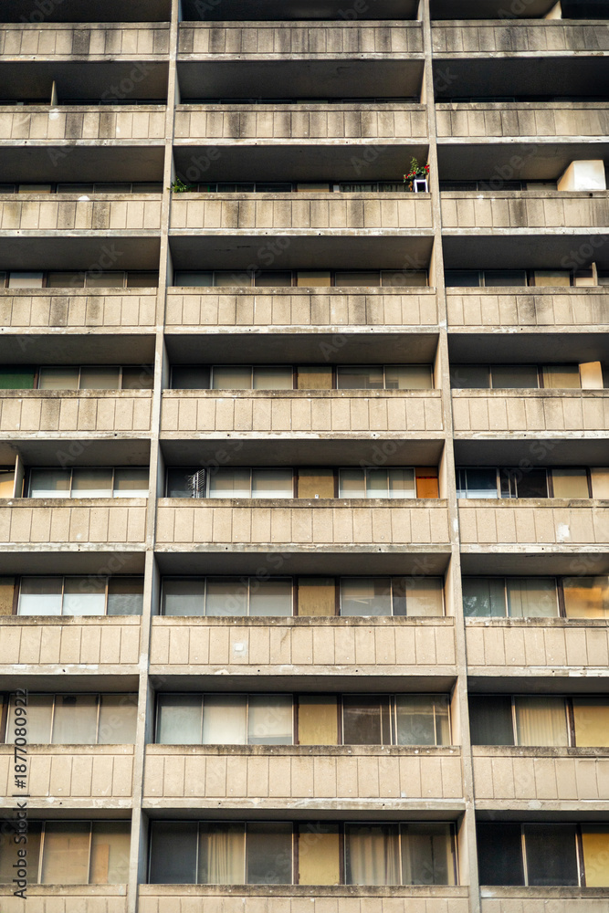 Repetitive concrete apartment building facade with balconies and ...