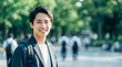 © miko - 新緑の公園で私服姿で笑顔の日本人男子大学生
