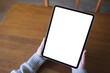 © Farknot Architect - Top view mockup image of a woman holding digital tablet with blank white desktop screen on wooden table