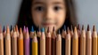 © Ndoomyim - Young girl concentrating on vibrant assortment of colored pencils for art project.