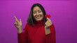 © Krakenimages.com - Woman smiling holding red heart and pointing on pink background symbolizing love and happiness.