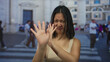 © Krakenimages.com - Young woman on city street makes gesture of rejection outdoor with blurred buildings and people in background, expressing displeasure and disapproval in urban environment.