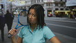 © Krakenimages.com - Young chinese woman with tennis racket looking pensive on city street outdoor scene.
