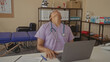 © Krakenimages.com - Woman doctor with stethoscope tilts head back exposing neck at clinic desk with laptop and telephone; fatigue burnout resilience.