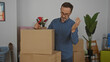© Krakenimages.com - Hispanic man packing boxes in living room of new home with a focused expression, displaying a mature and thoughtful demeanor.