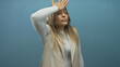 © Krakenimages.com - Woman holding forehead in realization against isolated blue wall expressing surprise in modern attire
