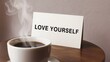 © Anastasiia - Cup of coffee with love yourself card on wooden table