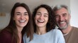 © Bussakon - Two women and a man laughing heartily together in a warm indoor setting