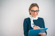 © Nenad - Smiling business woman holding clipboard and pen writing document isolated on white background