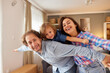 © Stockphotodirectors - A family shares a fun moment together in their cozy living room. Parents smile as they playfully pose with their child, creating lasting memories of joy and love at home.