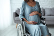 © Anna - Pregnant woman in wheelchair, maternity portrait, blue dress, light background
