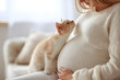© Anna - Pregnant woman with kitten, cozy maternity scene, beige tones, light background