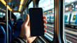 © Prime Layer Studio - Realistic hand holding smartphone with blank black screen on commuter train, mobile app mockup concept