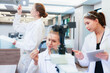 © ultramansk - Diverse team of female scientists working in busy digital pathology lab. Researchers analyzing histology slides using microscope, tablet, and visual inspection for medical diagnosis.