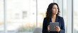 © Five Million Stock - 40s mature professional business leader executive woman office worker holding tablet computer isolated. Latin hispanic middle aged businesswoman thinking, dreaming looking away. Web banner, copy space