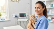 © Dara - A young woman in a blue uniform holding a ginger kitten in a veterinary clinic.