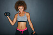 © peopleimages.com - Exercise, weights and portrait of woman in studio for fitness, strength training and bodybuilding. Mockup space, workout and person with dumbbells for muscle, strong arms or health on gray background
