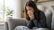 © Leo - Sick woman sneezing into tissue, suffering from flu or cold at home, concept of seasonal illness, allergy or virus infection symptoms, cozy indoor background