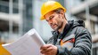 © DreamGlyphs - A construction worker examines blueprints on-site, wearing a safety helmet and jacket, focused on the project details.