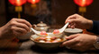 © Solos - People eating hot Tang Yuan ginger soup with pink and white rice balls for celebration.
