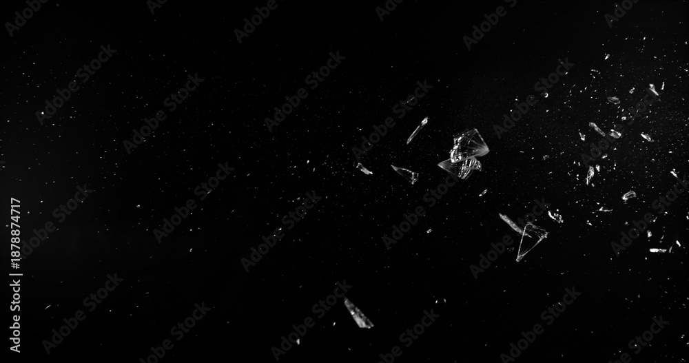 Side angle photo of flying shattered glass shards and dust isolated on black background. High detail debris explosion, perfect for VFX overlay, compositing, transitions or dramatic design elements.