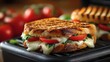 © Zarana  - Gourmet grilled panini sandwich with melted mozzarella cheese, fresh tomatoes, and basil on a panini press