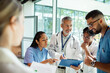 © Marko Geber - Doctors and nurses discussing patient chart in hospital corridor
