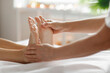 © Home-stock - Mindful Relaxation. Woman receiving foot massage, masseur presses energy flow points in spa center calm interior, closeup