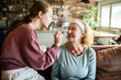 © Geber86 - Teen girl applying face mask to senior woman at home