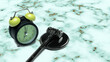 © Leo Lintang - A composition showing a black alarm clock and a judge's gavel on a teal marble background, symbolizing legal deadlines, courtroom proceedings, or auction time