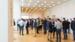 © Rahman - Blurred image of a large group of business people networking and socializing at a corporate conference or event in a modern hall with warm lighting