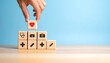 © Innovative - Hand placing heart block atop healthcare icon pyramid on blue