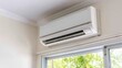 © Emilio - Air conditioner installed above window with natural light and greenery outside. Indoor air quality and sustainable cooling solution. Climate control for comfortable living