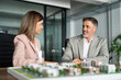 © insta_photos - Real estate developers brokers presenting new residential city building development construction luxury housing project architectural model. Investing in realty, bank mortgage loan concept.