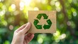 © Attala Rizky - Human Hand Holding Recycled Paper Card with Green Symbol for Reduce Reuse Recycle and Environmental Sustainability Concept