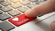 © Chris - Finger pressing red donate button on laptop keyboard.