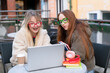 © Iryna - Friends work together on school project outside during sunny day with laptop and books