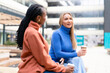 © Iryna - Friends chat over coffee in an outdoor urban setting during daytime