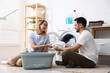 © New Africa - Couple doing laundry together at home. Domestic chores