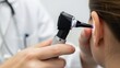 © Gakpo - Doctor examining patients ear with otoscope for medical checkup.