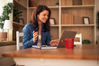 © Jelena - Woman making video call while working from home