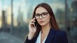 © LimeSky - Image of an attractive young businesswoman in glasses speaking on a phone near a structure.png