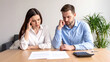 © corlaffra - A young couple looking frustrated and worried, showing the emotional struggle of financing their new home.