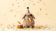 © Pink Zebra - Cute brown lop-eared rabbit wearing a colorful party hat and holding a party blower, small carrot cake with lit candle and falling confetti, celebrating a work deadline or office birthday.